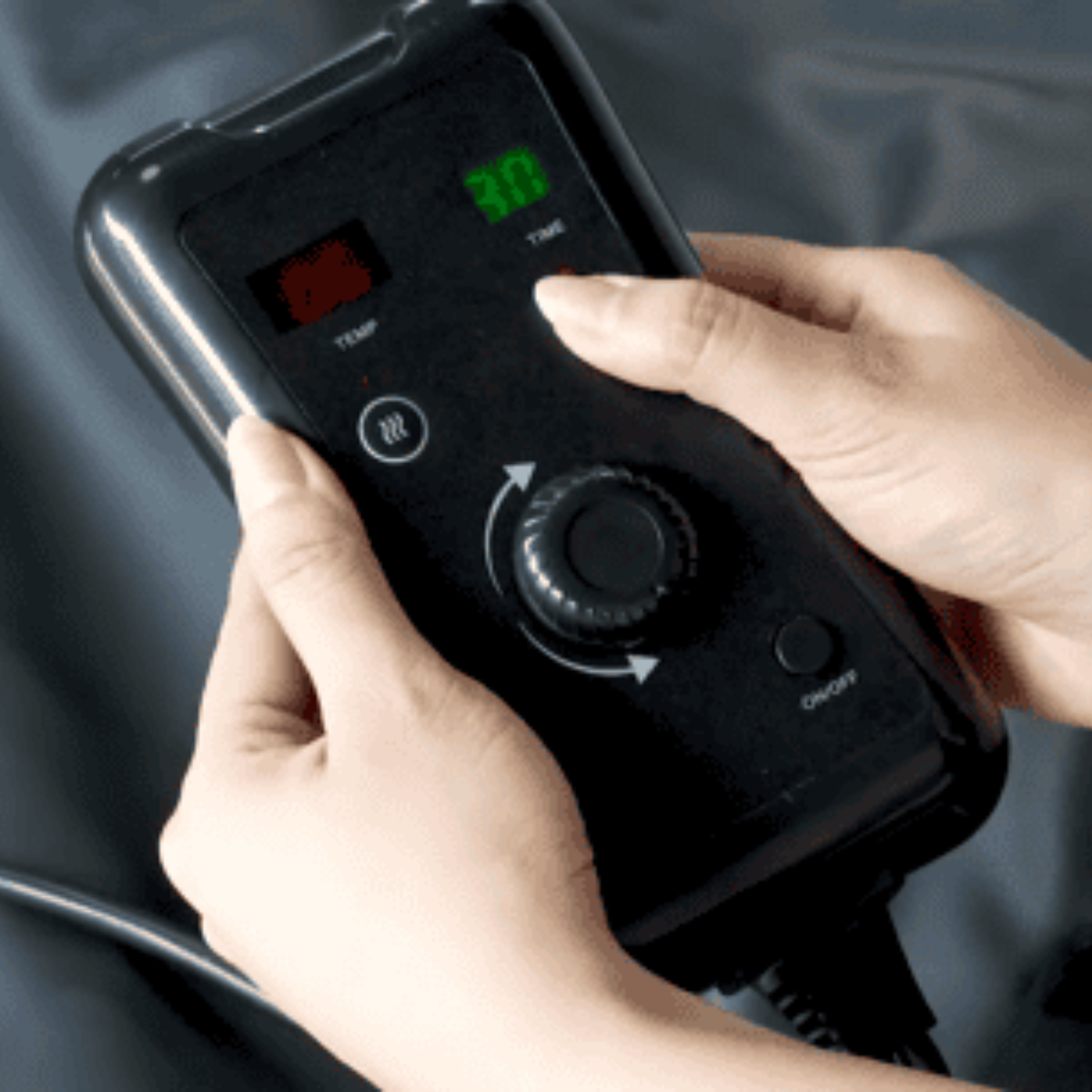 Person adjusting a digital control panel with a focus on the hands and device.