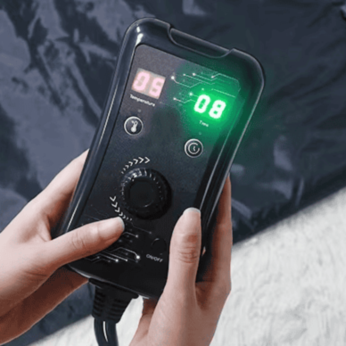 Person holding a digital device with a green display and control panel.