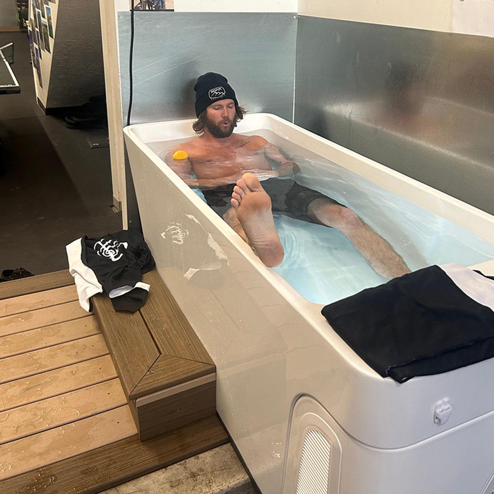 Man sitting in an Airvida Cold Plungel with towels on the side.