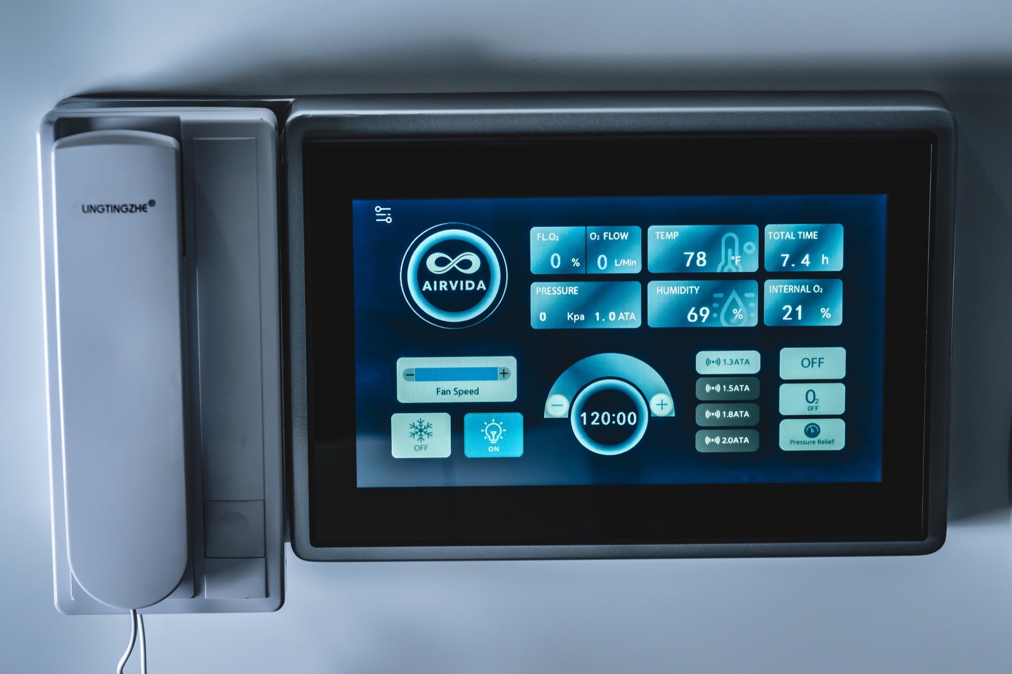 Close-up of an Airvida hyperbaric chamber touchscreen showing pressure, oxygen flow, temperature, humidity, and session controls.