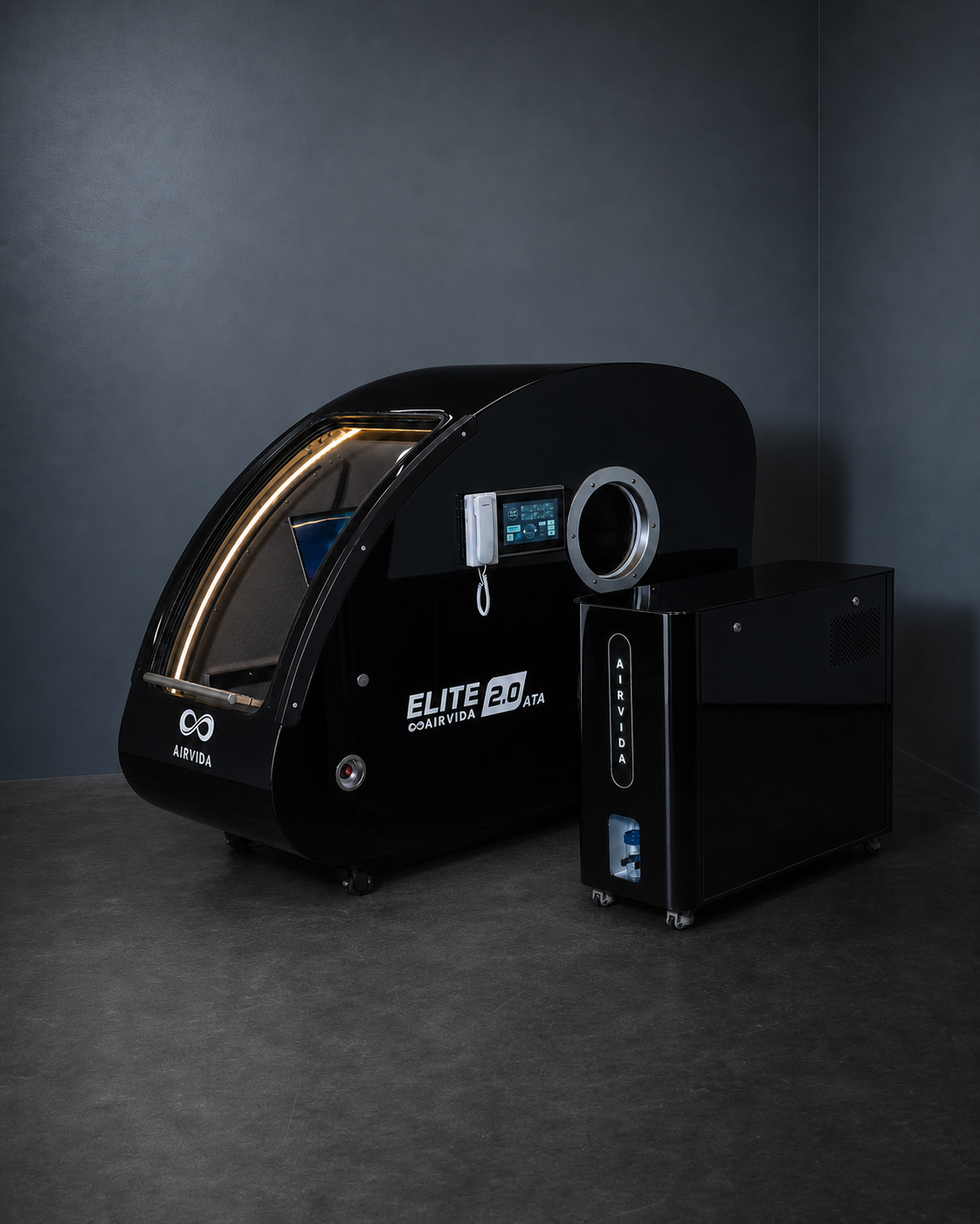 Black AIRVIDA Elite 2.0 ATA hard-shell hyperbaric chamber with touchscreen, viewing port, illuminated entry, and separate oxygen control unit.