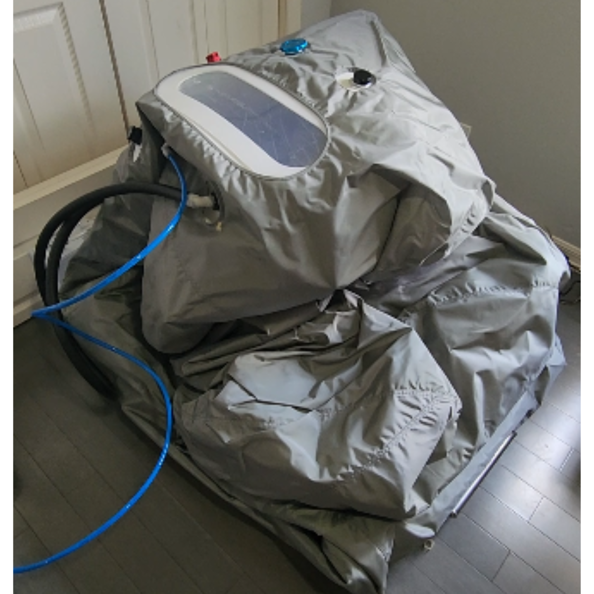 Deflated Airvida soft hyperbaric chamber with connected hoses before setup