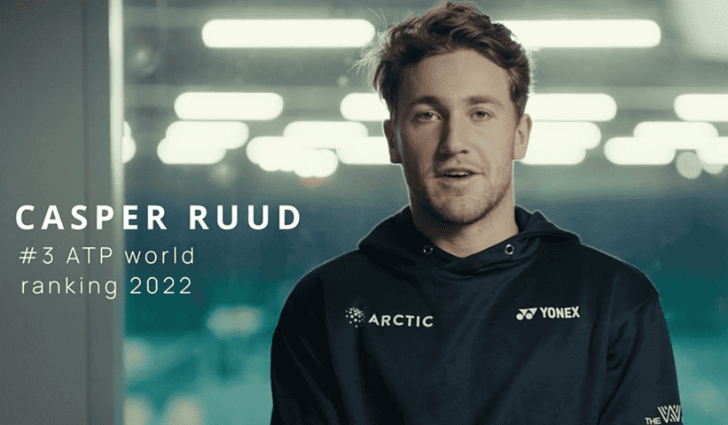 Person wearing a black hoodie with visible branding, standing in front of a blurred background with 'Yonex' logo.