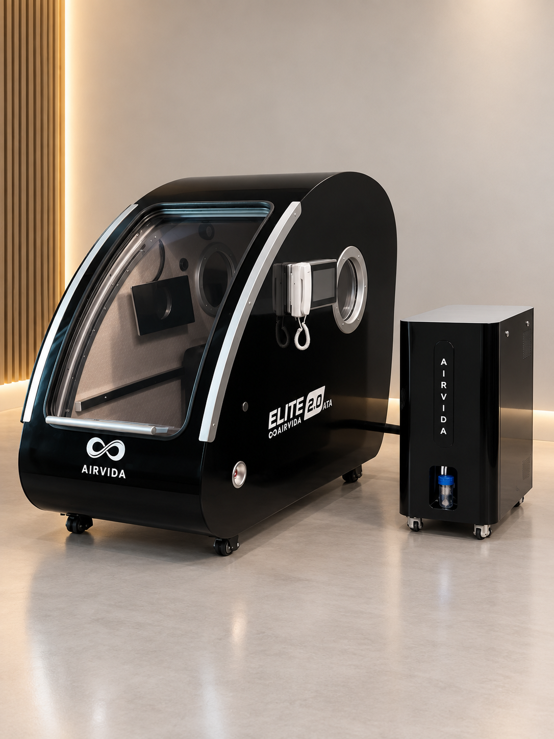 Black Airvida Elite 2.0 ATA hyperbaric chamber with clear curved door, digital controls and matching oxygen unit displayed in a sleek modern wellness room.