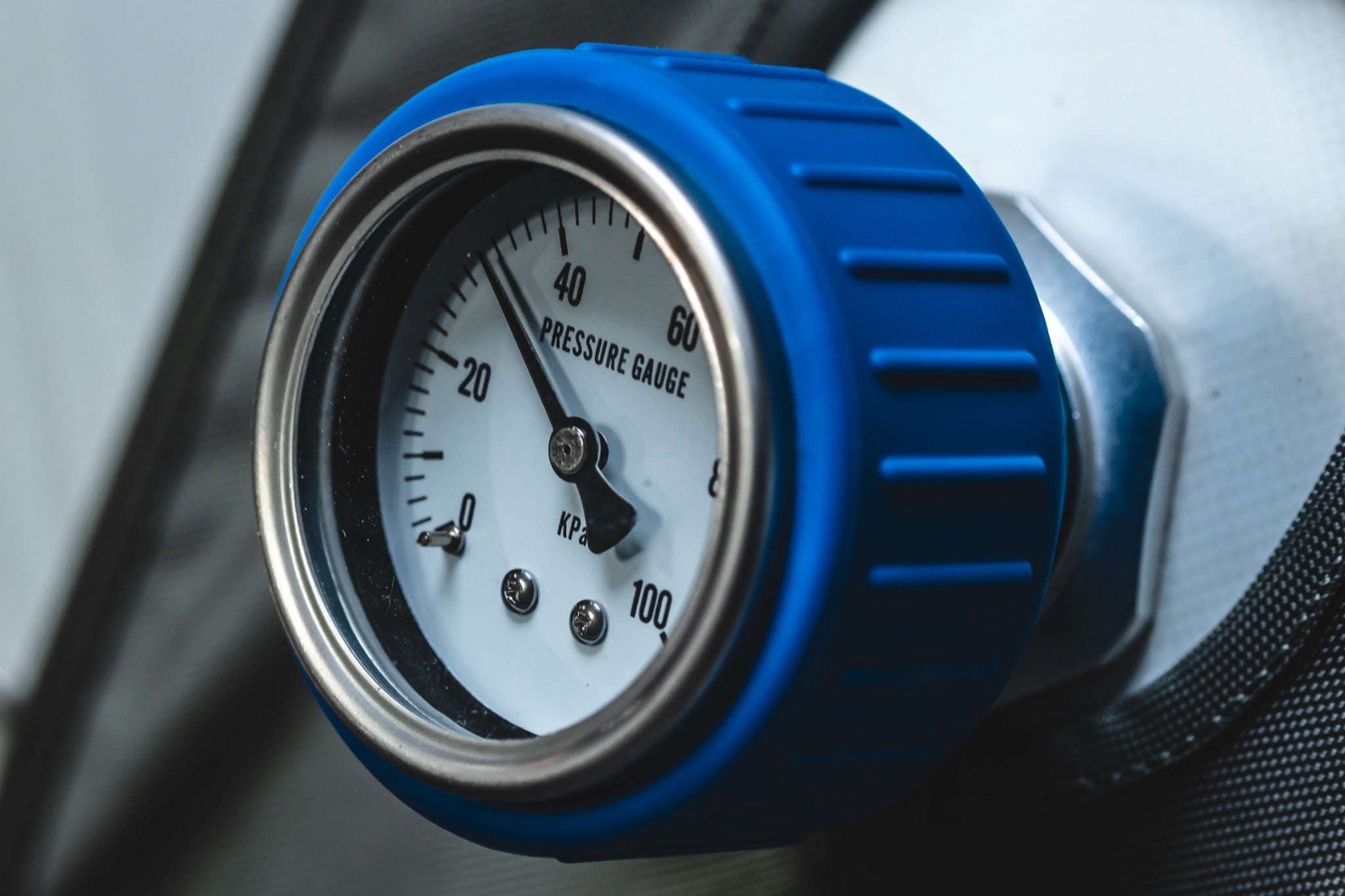 Close-up of a blue-rimmed pressure gauge on an AIRVIDA hyperbaric chamber, displaying pressure levels from 0 to 100 kPa for easy monitoring.