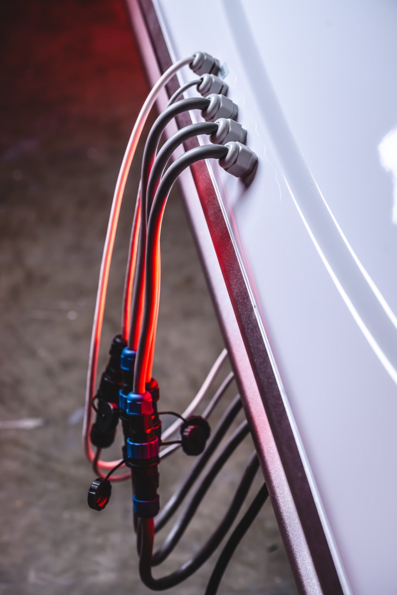 Close-up of multiple black and clear hoses connected to fittings along the side of an AIRVIDA unit, with secure valves and tubing connections.