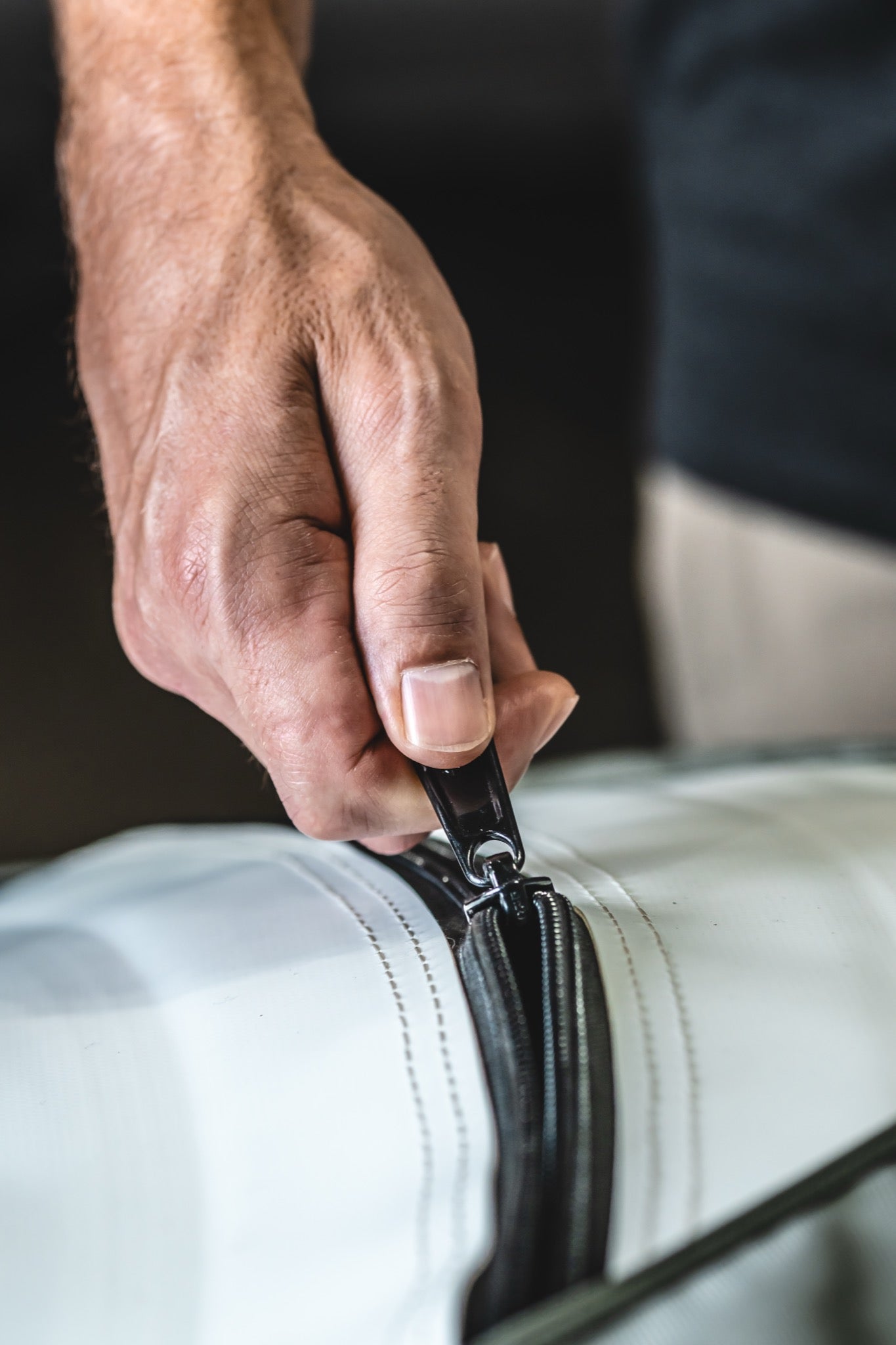 Close-up of a person securely closing the heavy-duty zipper on an AIRVIDA hyperbaric chamber, highlighting its durable construction and seal.