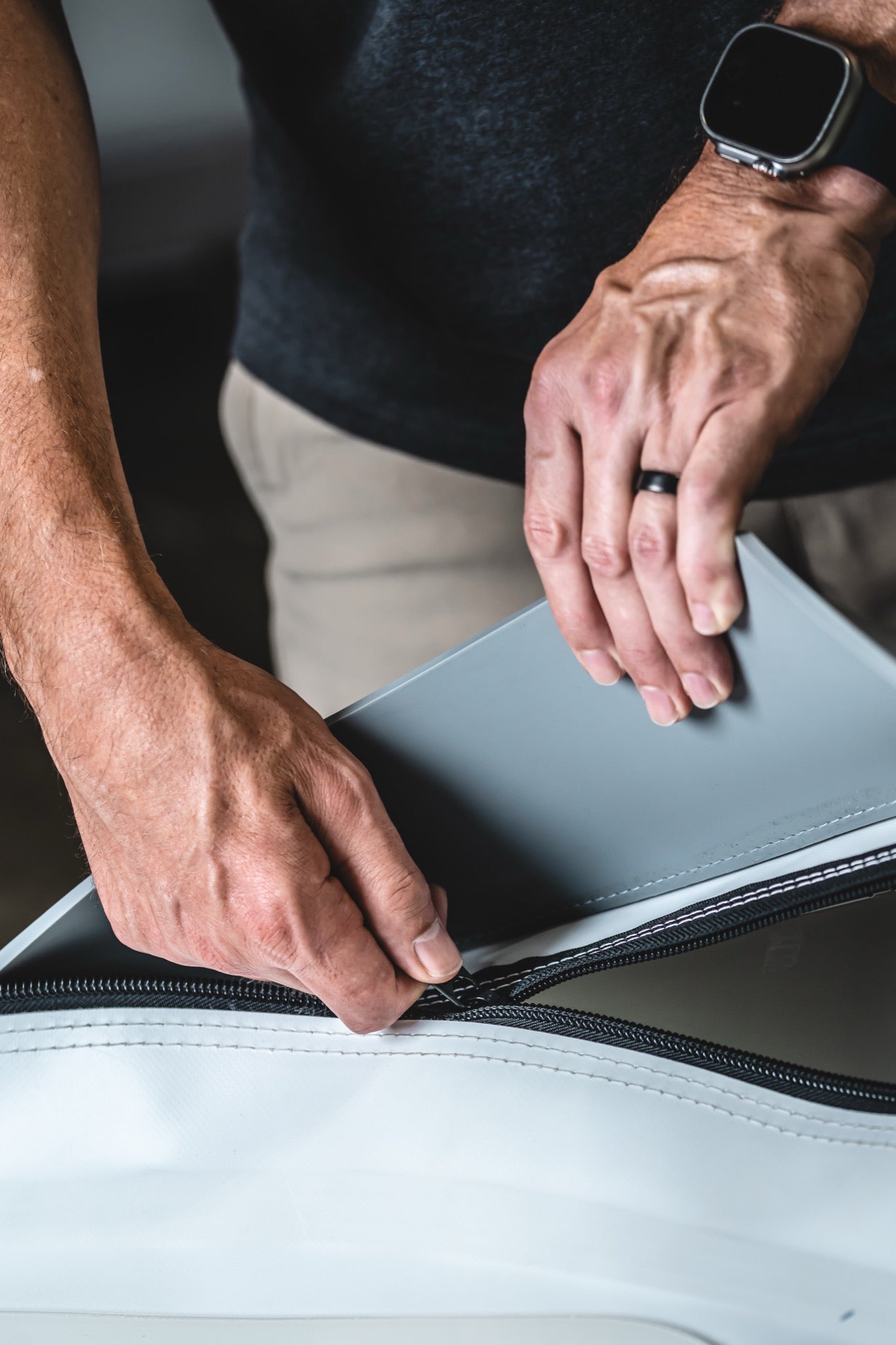 Close-up of a man opening the heavy-duty zipper and inner flap of an AIRVIDA hyperbaric chamber, highlighting its secure and durable design.