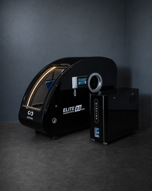 Black AIRVIDA Elite 2.0 ATA hard-shell hyperbaric chamber with touchscreen, viewing port, illuminated entry, and separate oxygen control unit.