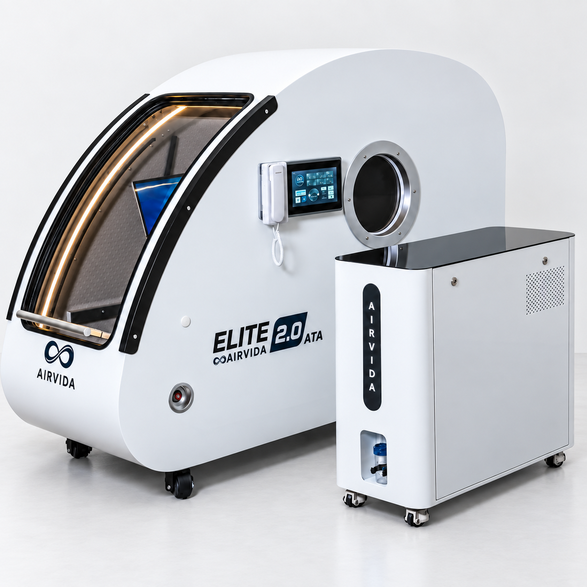 White Airvida Elite 2.0 ATA hyperbaric chamber with touchscreen, viewing port and matching Airvida oxygen unit on wheels in a clean modern clinical setting.