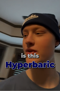 Person wearing a beanie indoors, looking to the side, with on-screen text reading “is this Hyperbaric